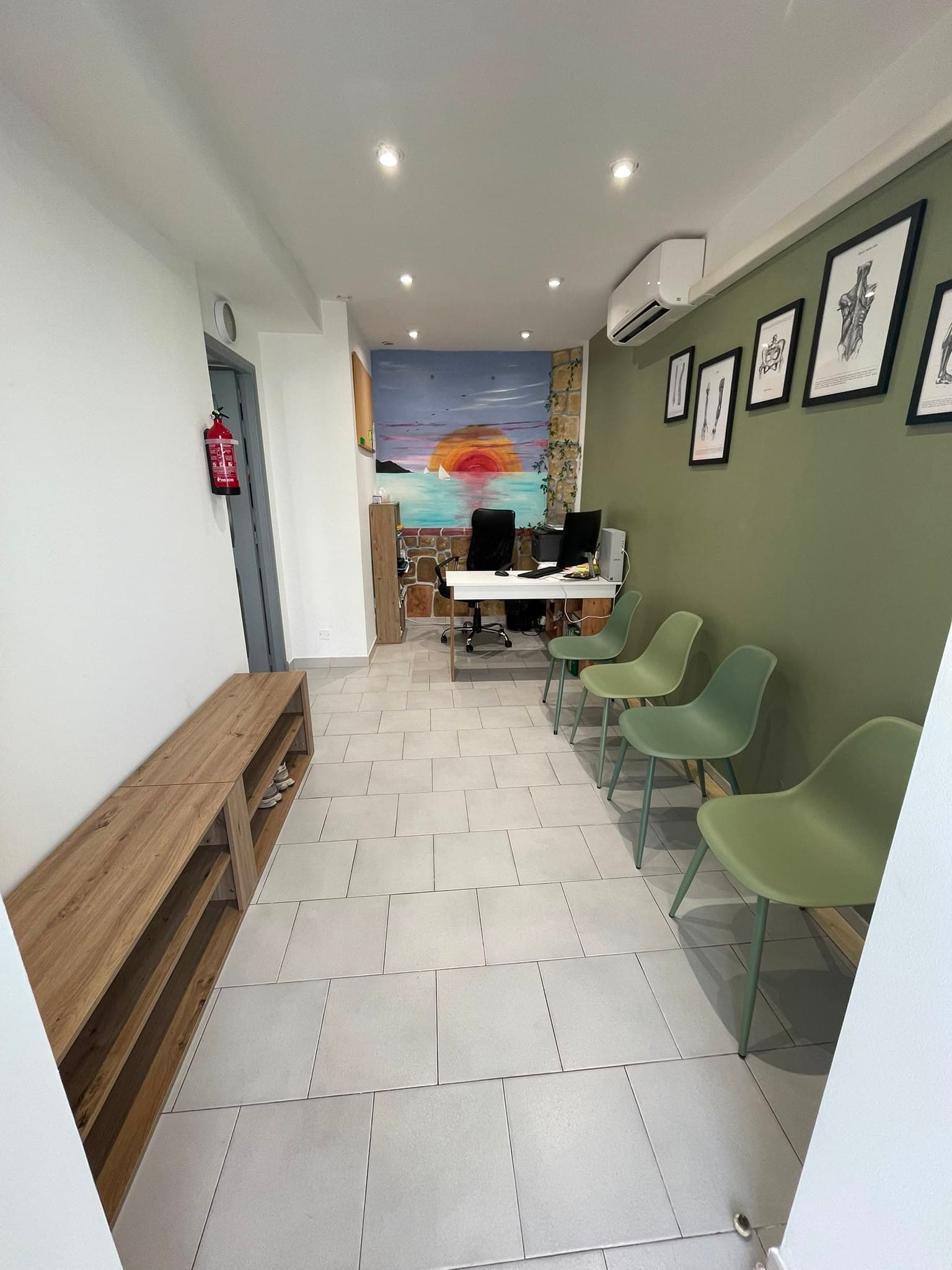 Salle d’attente du cabinet Mouve’O avec chaises vertes et fresque colorée